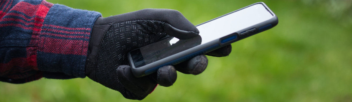 Close up of glove using phone