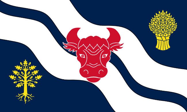 A blue flag with a red ox head on a double white waves, between a gold wheatsheaf and a gold oak